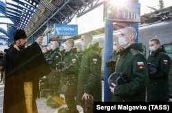 Священник РПЦ и призывники на платформе железнодорожного вокзала в Севастополе. 3 декабря 2021 года