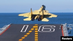 Китайский палубный истребитель "Шэньян J-15", взлетающий с китайского авианосца "Ляонин"