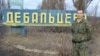 Казак Евгений Панчук у стенда названием украинского города Дебальцево, на котором можно увидеть надписи "Новосибирск", "ВДВ".