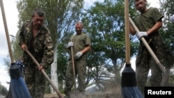 Пленные украинские военные подметают улицы в городе Снежное Донецкой области
